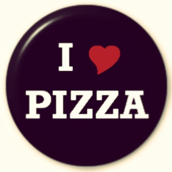 A circular button with "I (heart symbol) PIZZA" written in white text on a dark background.